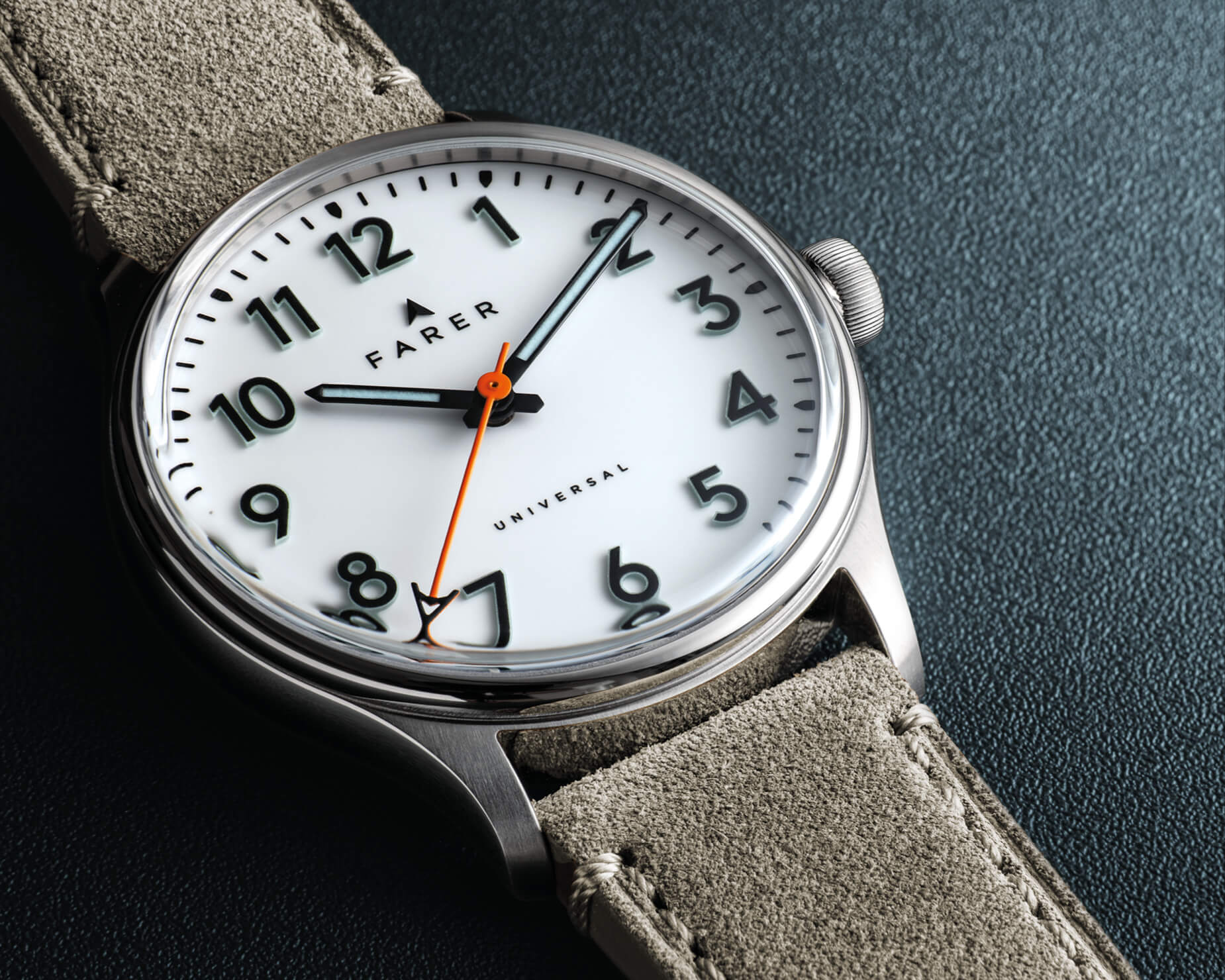 Close-up of Farer Resolute III white enamel dial and orange seconds hand on suede strap