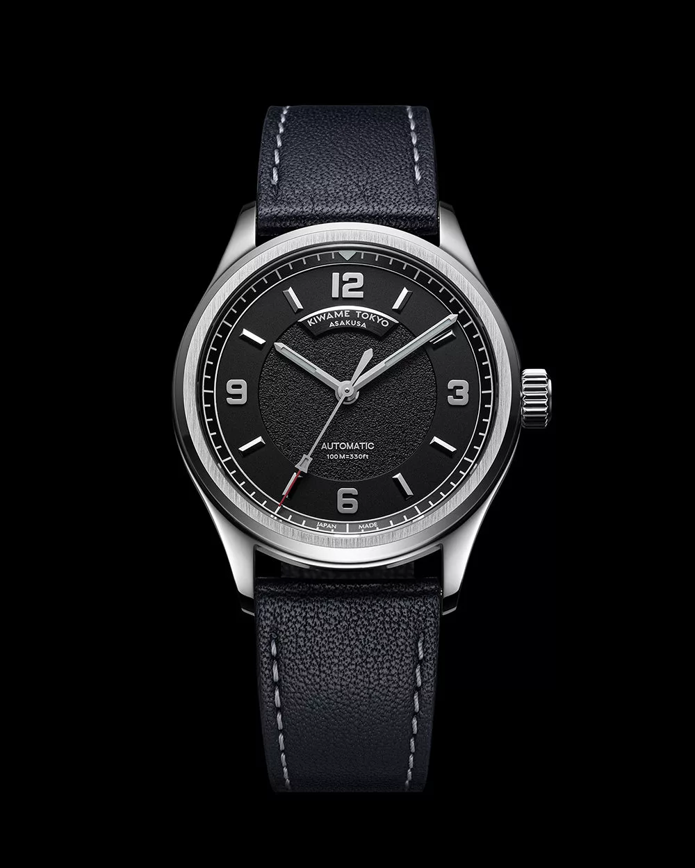 Front view of automatic wristwatch with black dial, Arabic numerals, stainless steel case, and leather strap