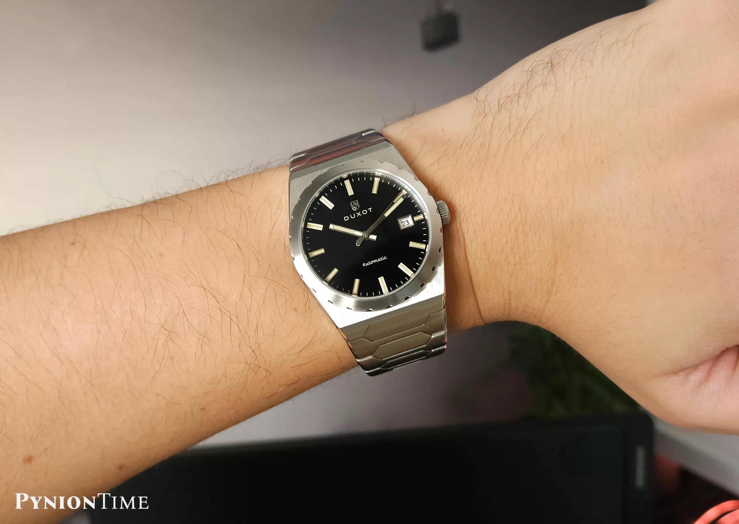 It features a matte black dial with applied metallic indices and no texture