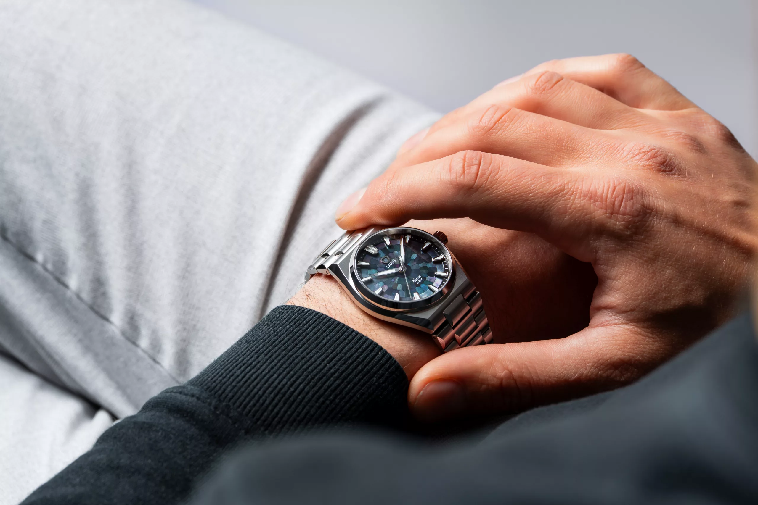 It features a custom Tapisserie dial pattern that repeats the bracelet's curve across the face
